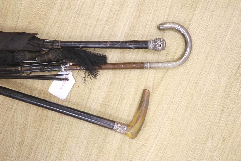 A silver collared horn handled cane and two silver handled parasols